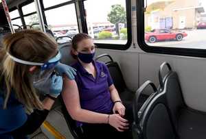 A nurse giving a COVID-19 vaccination on the SARTA bus.